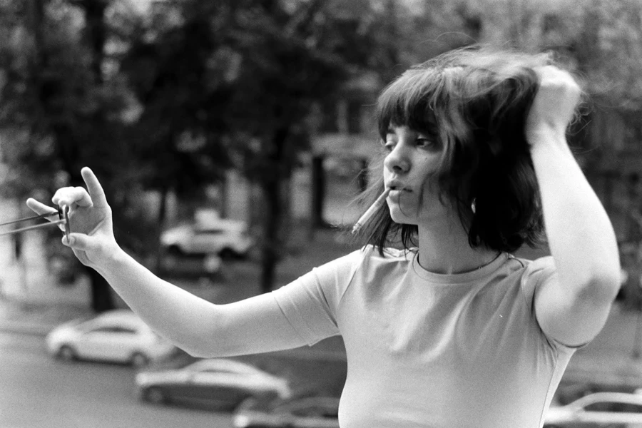 a black and white photo of a woman holding a pair of scissors