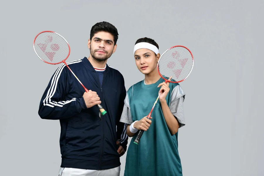 a man and a woman holding tennis rackets