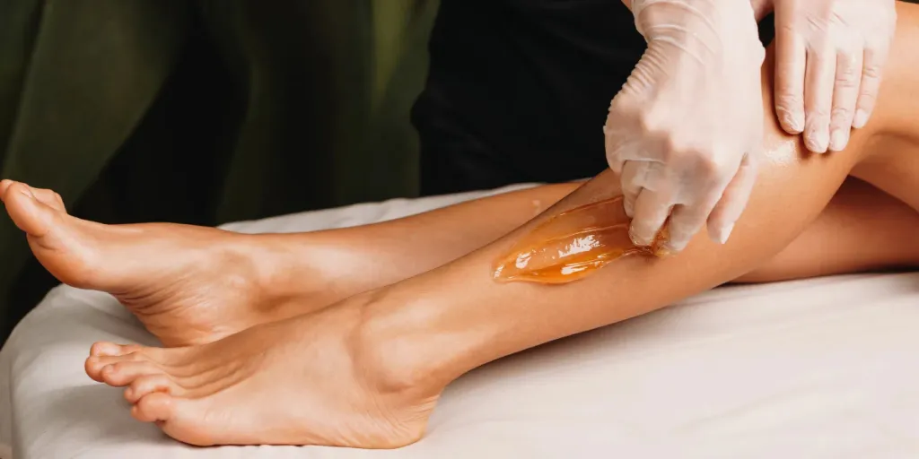 A woman getting a sugaring procedure at a salon