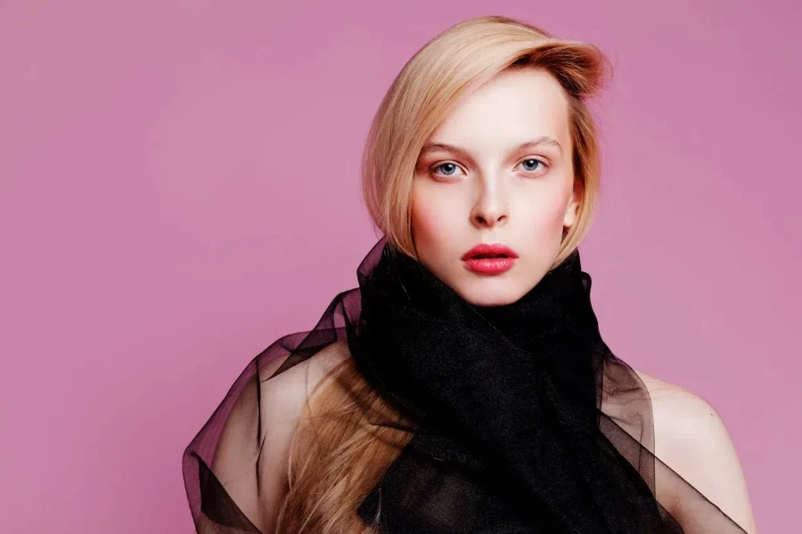 A woman wearing a black scarf in eye-catching makeup