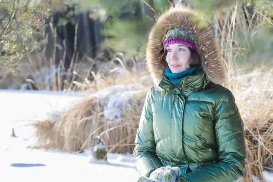 A woman wearing a green hooded quilted jacket