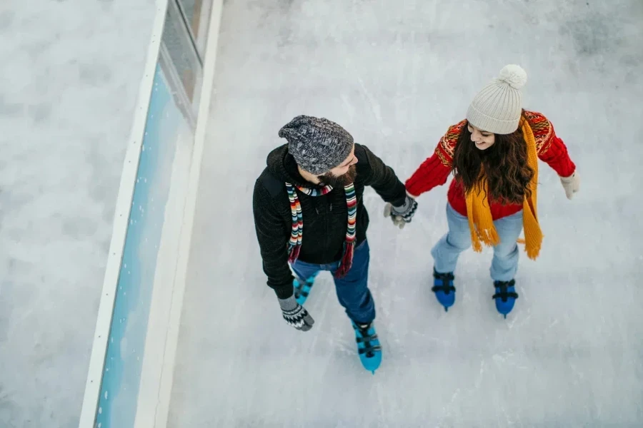 Pareja sobre hielo con patines deportivos azules ajustables