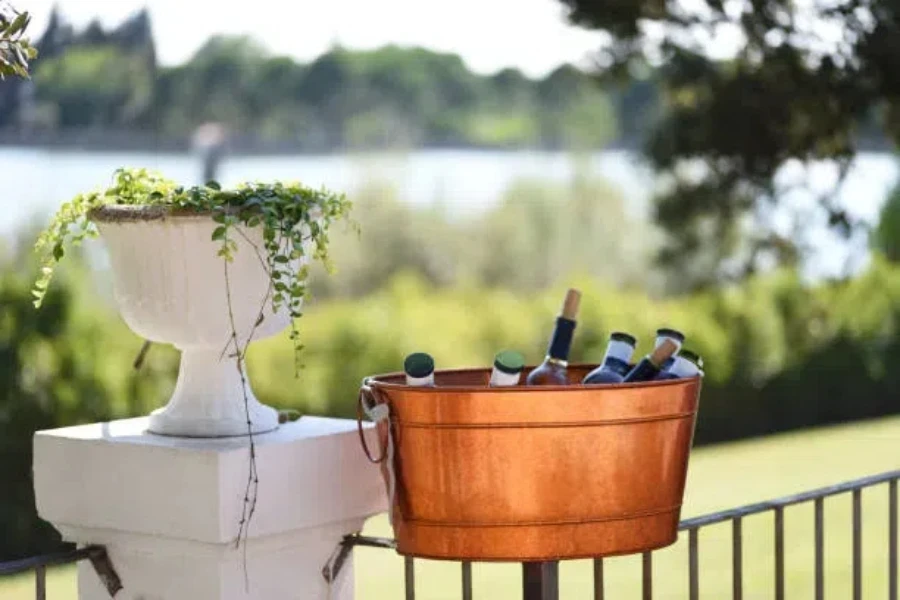 Gold ice bucket with beverages inside sitting on railing