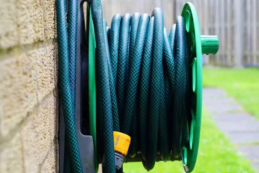 Grüner Wasserschlauch an der Wand befestigt