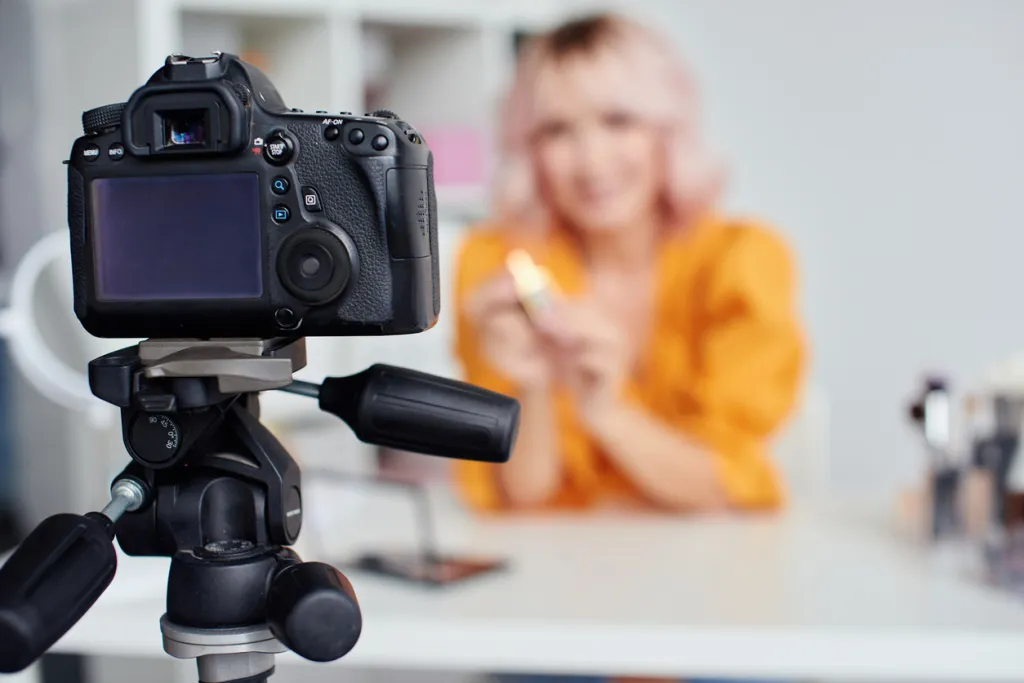 Une jolie femme enregistre une vidéo à la maison