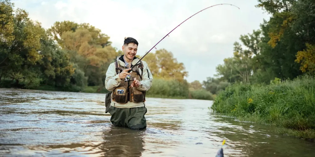 Mann zieht beim Angeln Fang aus dem Wasser