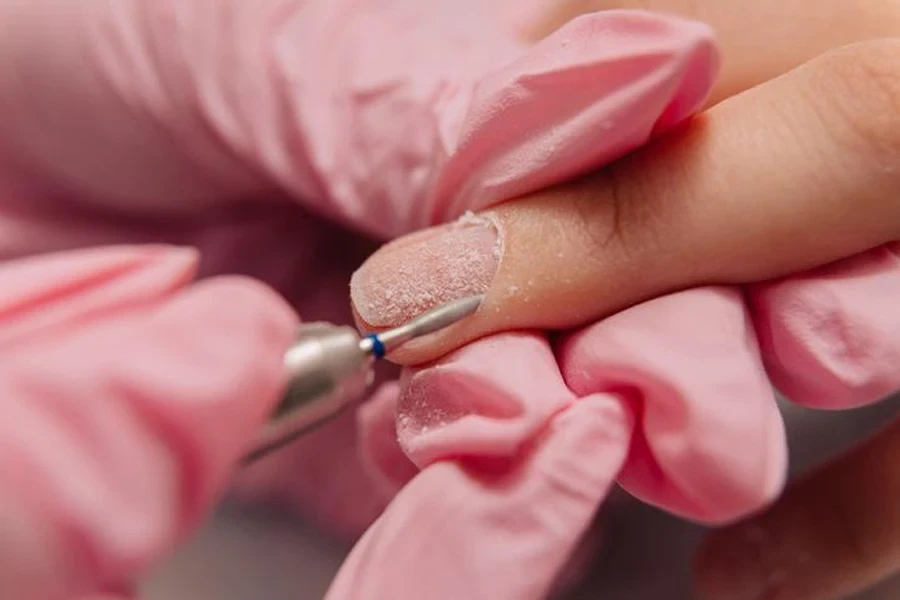 manicure process of a master polishes the nail using an automated machine drill