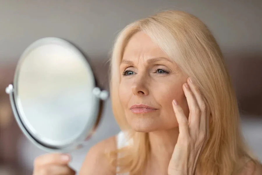 Mature woman looking at her appearance in a mirror