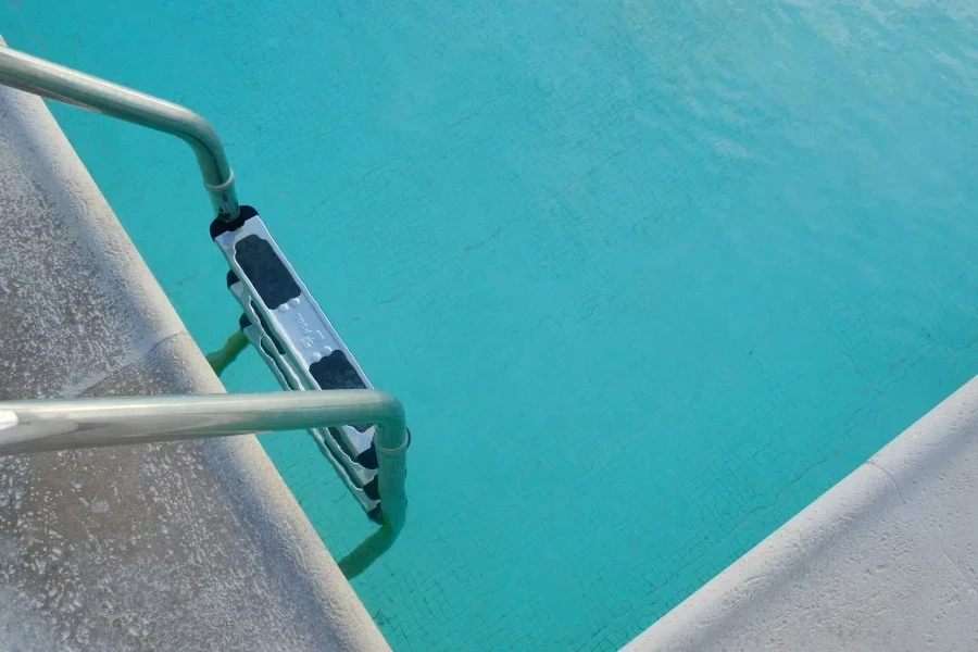 Escada de piscina de metal com pegadores pretos para os pés