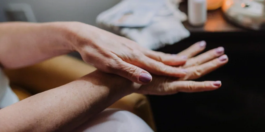 woman moisturizing her dry skin hands