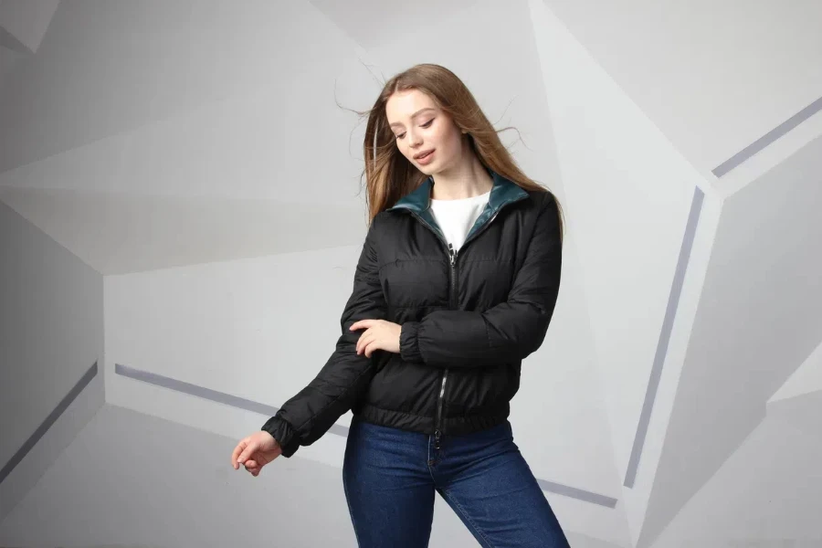 Woman posing in a black quilted bomber jacket