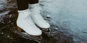 Femme portant des patins blancs sur un lac gelé