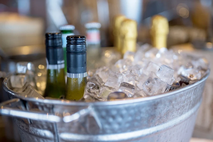 Un cubo de hielo lleno de hielo y botellas de vino.