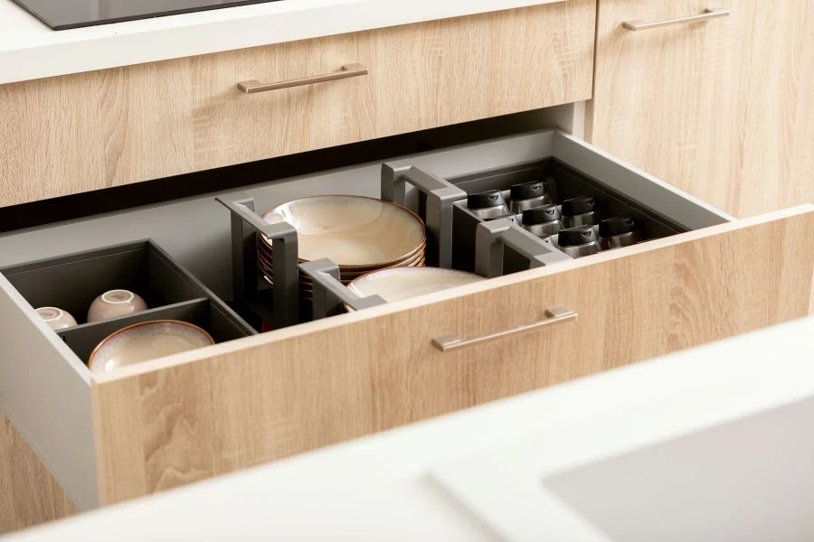 An open kitchen drawer with utensils