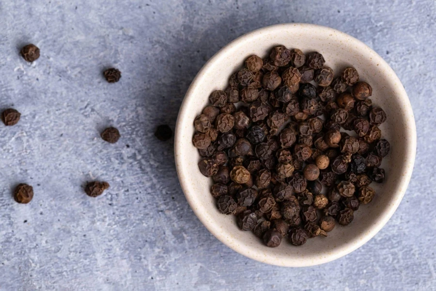 Black pepper in white bowl on kitchen countertop