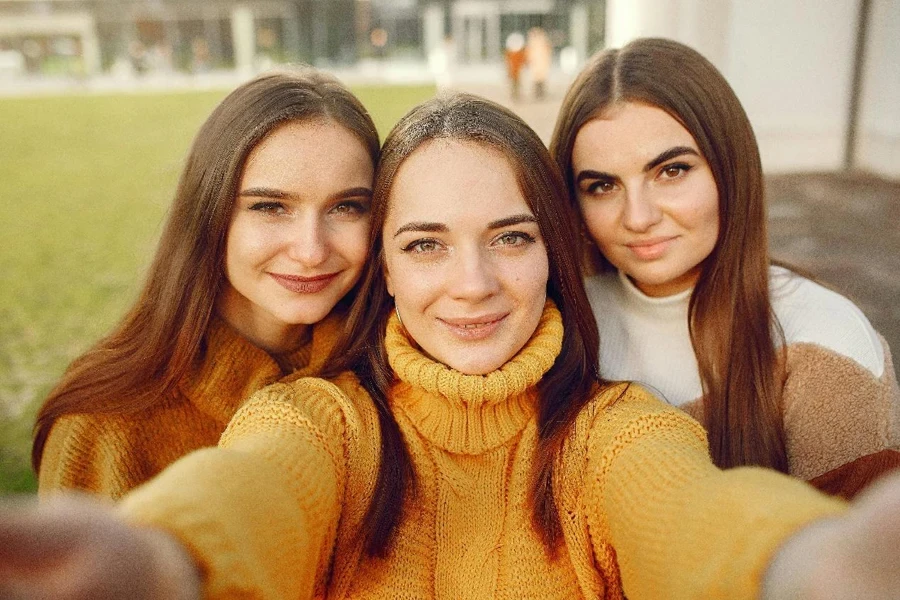 Happy girlfriends in park taking selfie