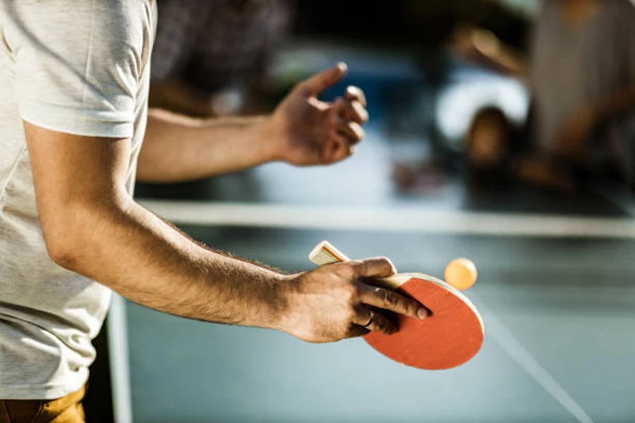 Jogador recreativo se preparando para bater uma bola de tênis de mesa durante o jogo