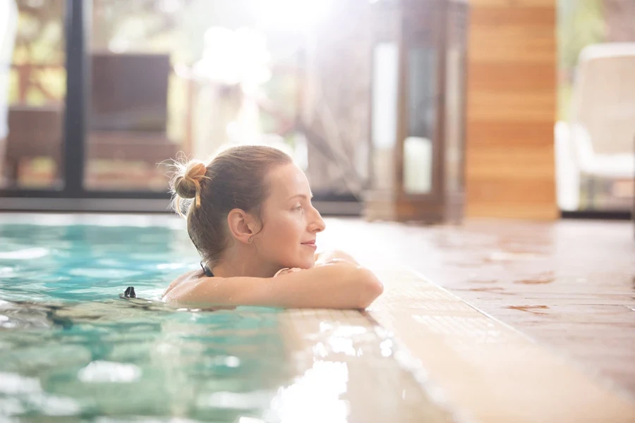 Vue latérale d'une femme au bord de la piscine