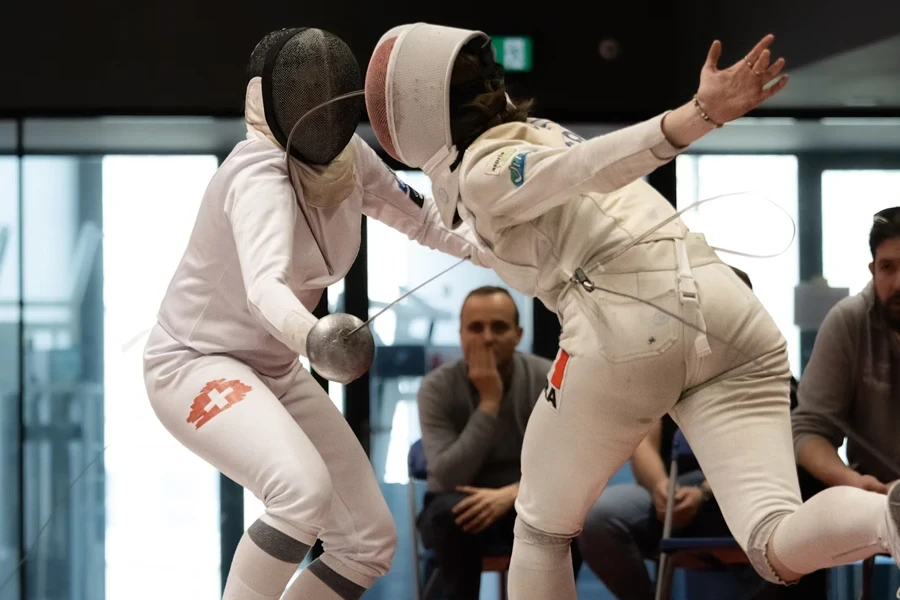 Two fencers wearing fencing gear