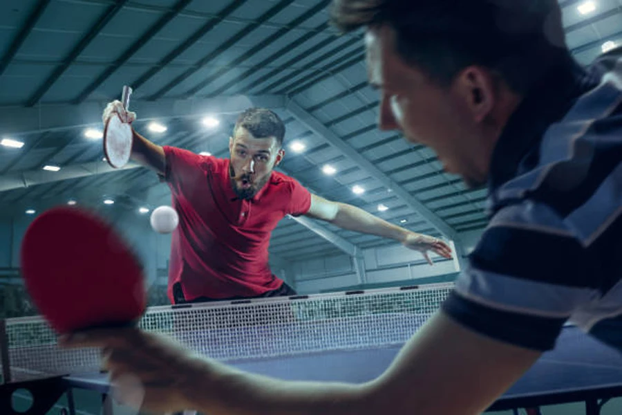 Dois amigos durante jogo de tênis de mesa com bola de 3 estrelas