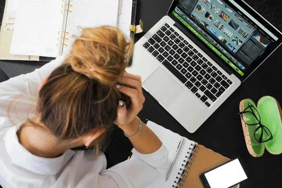 Donna che si tiene i capelli davanti al computer portatile