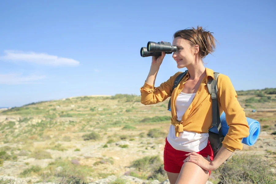 Woman in Yellow Long Sleeve is Holding Binocular