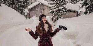 Mujer posando con un abrigo de invierno en la nieve.