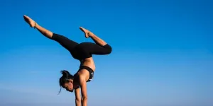 Mujer practicando yoga contra el cielo azul