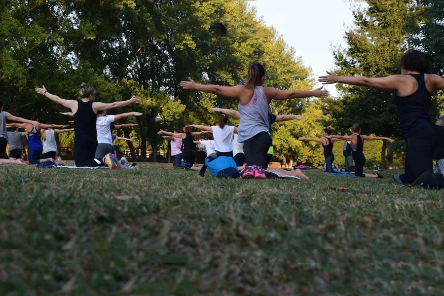 Women performing yoga on green grass