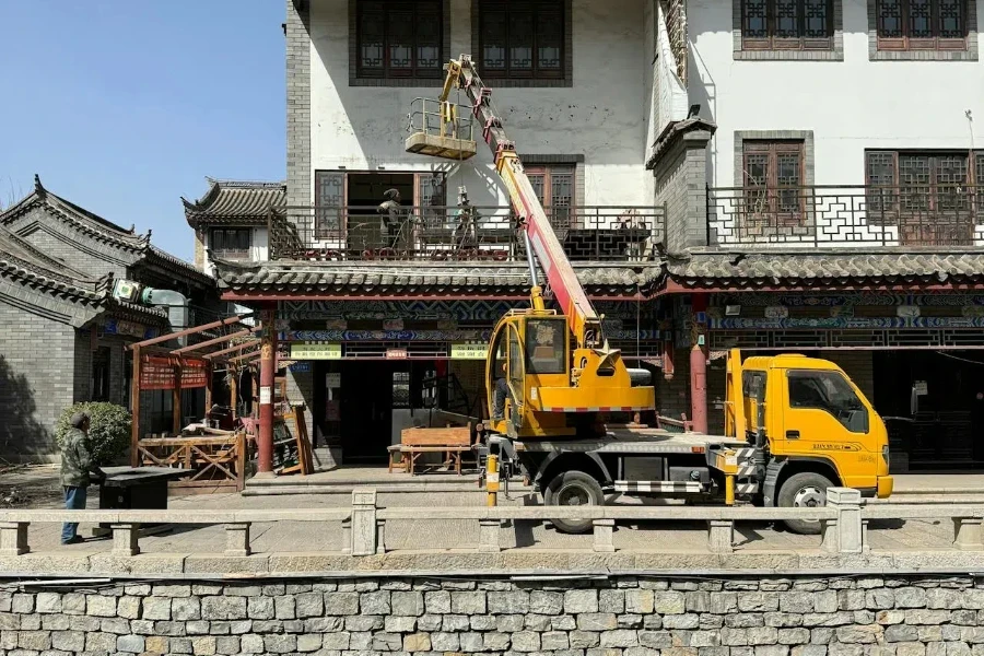 Ein LKW mit Ausleger bei der Arbeit an einem Haus in China