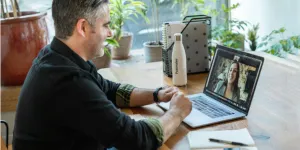 un uomo in una videochiamata di vendita con una donna sul suo laptop