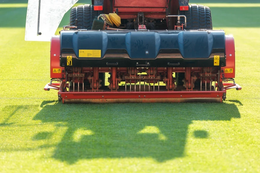 a tractor towing and aerating a field