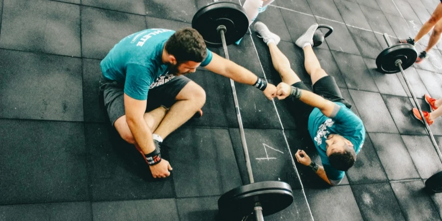 man fist bump to man laying on ground