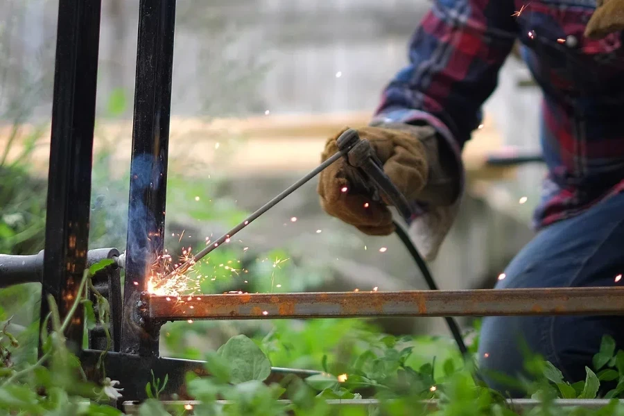 Man fusing two metal bars with a fusion welder