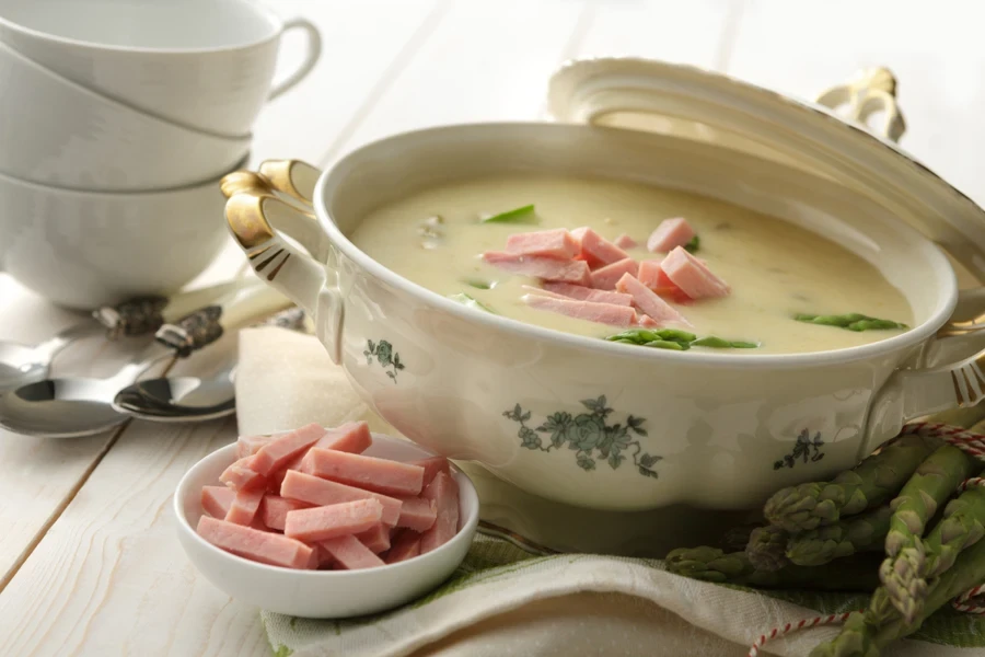 Uma terrina de sopa cheia em uma mesa de jantar