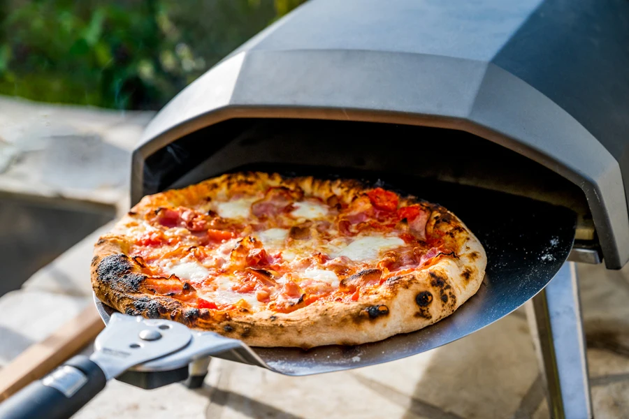 Uma pizza caseira assada em um forno portátil