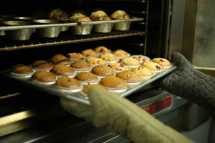 A person holding a tray of muffins