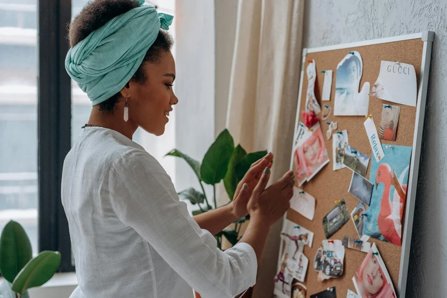 A person standing in front of a cork board