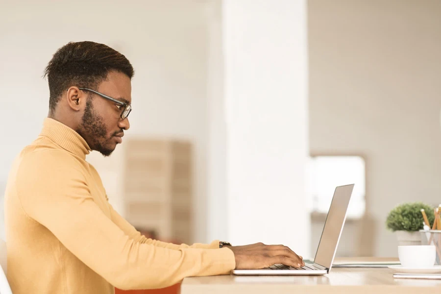 Um homem sério trabalhando em seu laptop