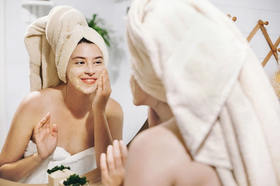 A smiling woman applying lightweight cosmetics during the day