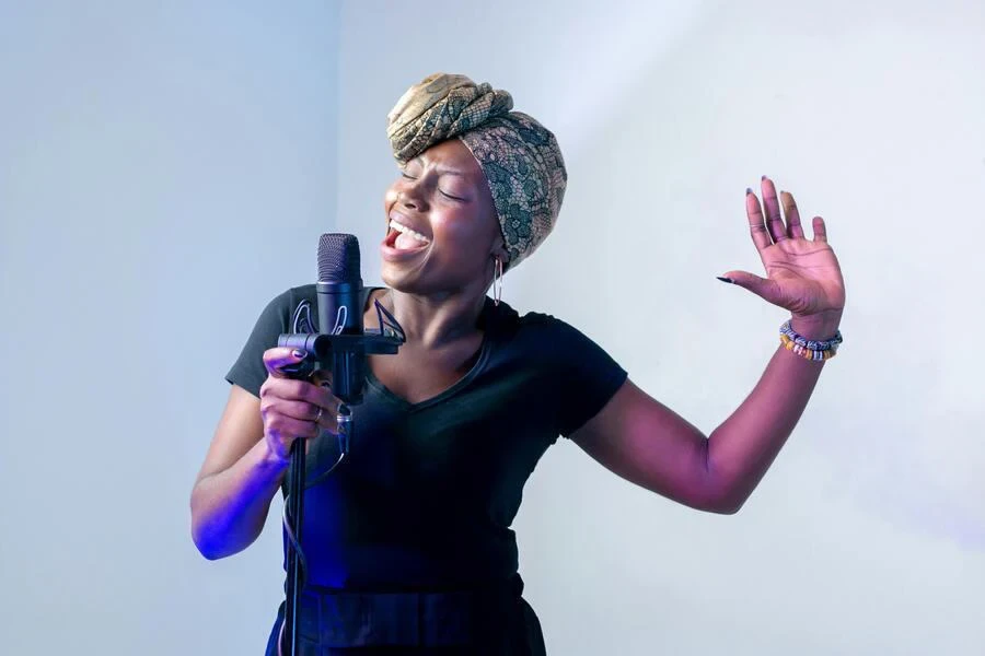 Une femme chantant avec un foulard sur la tête enveloppé dans un style turban