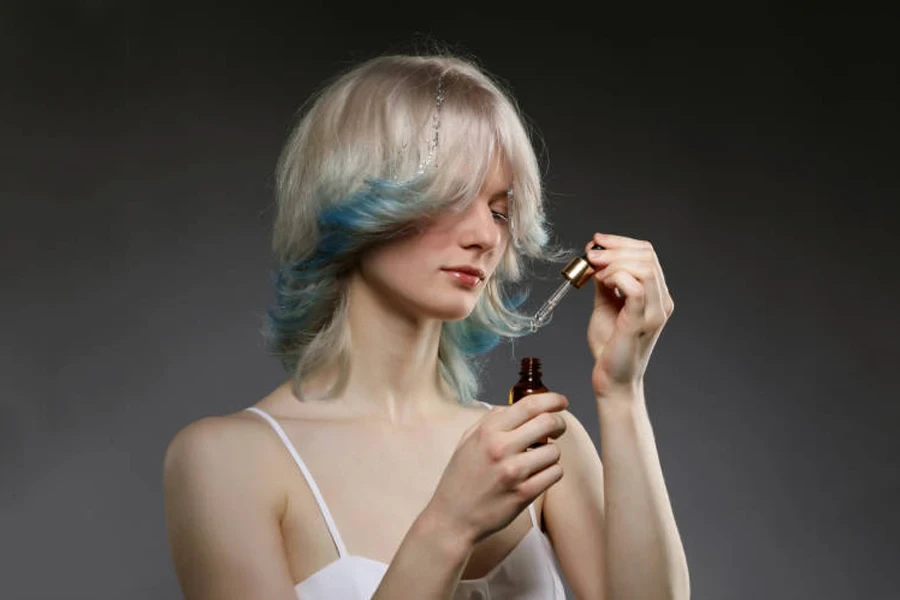 Belle jeune femme avec une coloration créative des cheveux en bleu