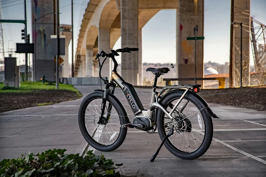 Bicicleta elétrica preta estacionada em pavimento de concreto cinza