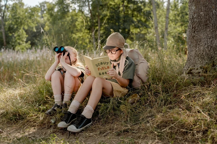 Blondes Mädchen schaut durch das Fernglas