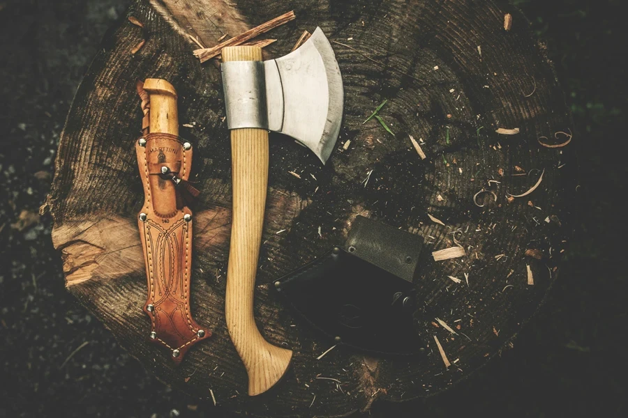 Hacha de madera marrón y funda de cuero marrón para cuchillos