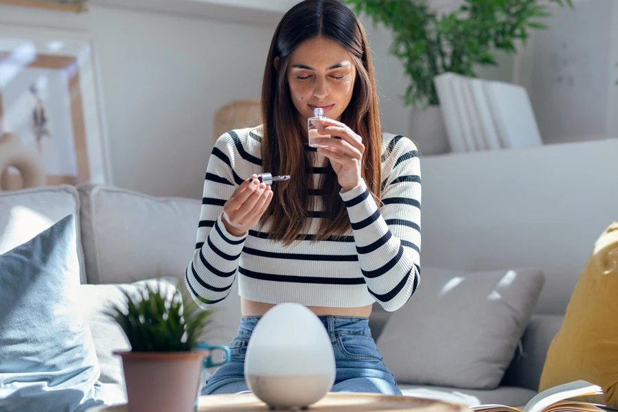 Femme joyeuse tenant une bouteille d'huile essentielle