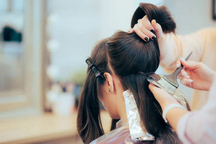 Coiffeur coupant et teignant les cheveux d'un client