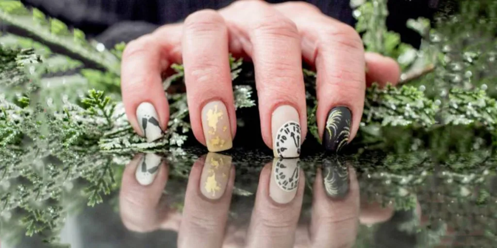 Main avec des ongles mignons et uniques inspirés du réveillon du Nouvel An