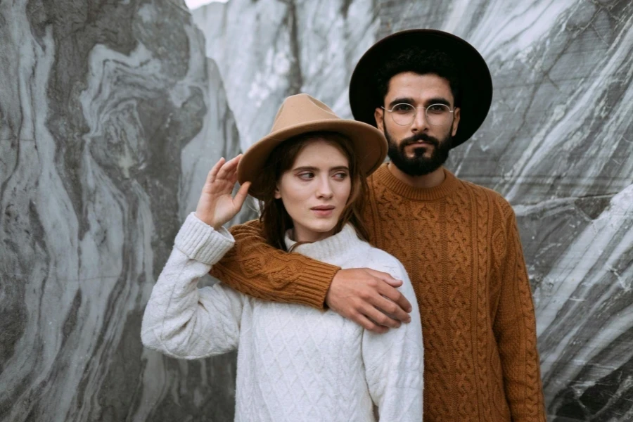 Man in Brown Knitted Sweater Hugging Woman in White Sweater