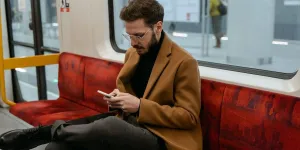 Man in a brown coat using his phone